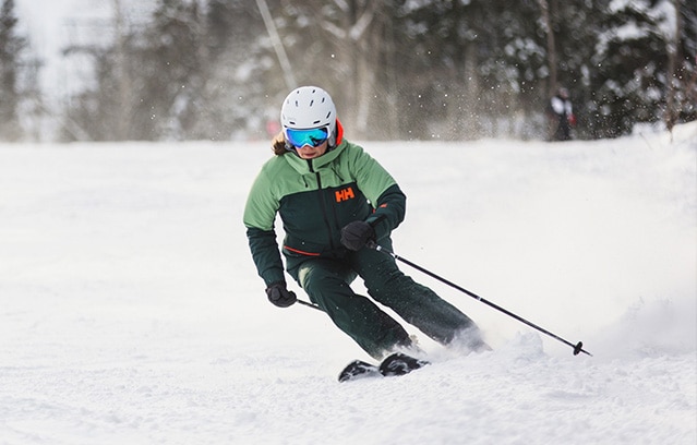 Un skieur de descente se déplace rapidement avec un équipement de Sports Experts